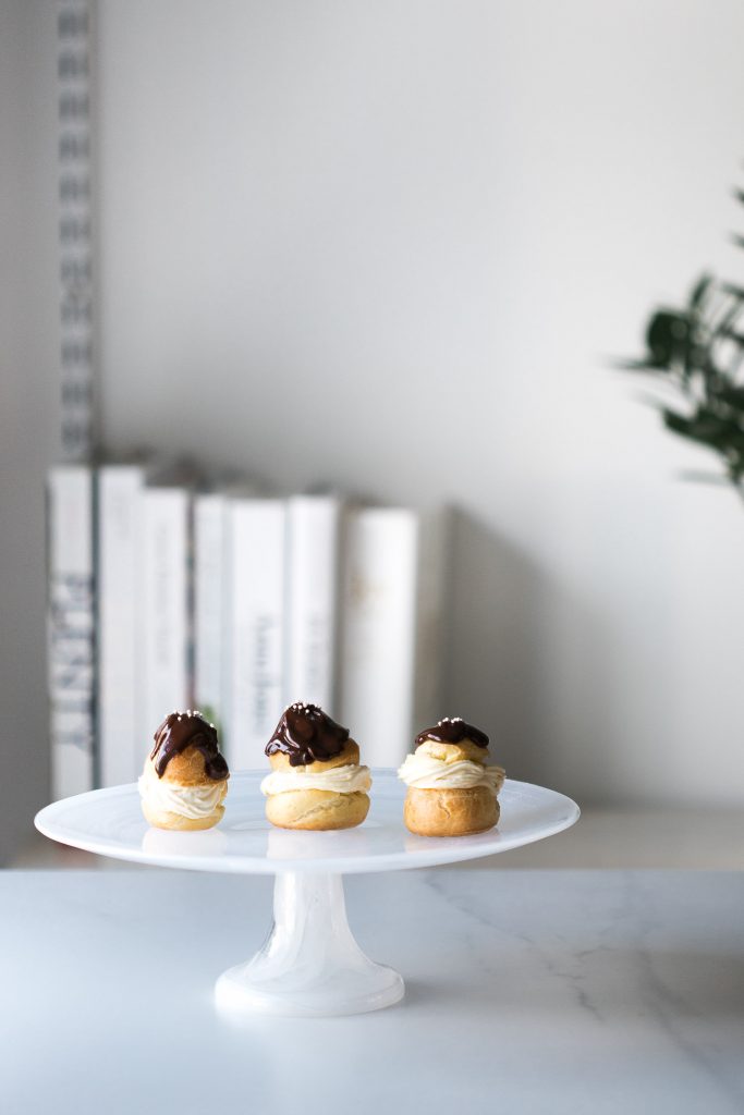 Shot of 3 Choux à la Crème sitting on a cake stand