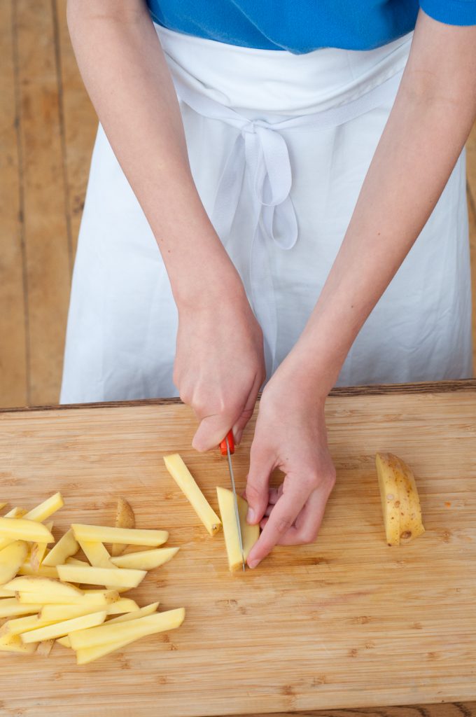Kids chopping potatoes for oven baked fries from In the French kitchen with kids by Mardi Michels