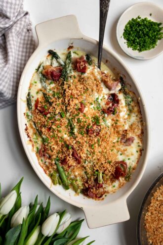Asparagus au Gratin with Prosciutto in a oval baking dish.