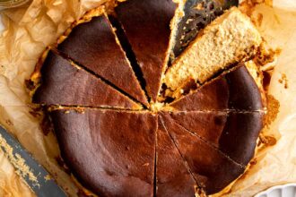 Sliced pumpkin basque cheesecake on parchment paper.