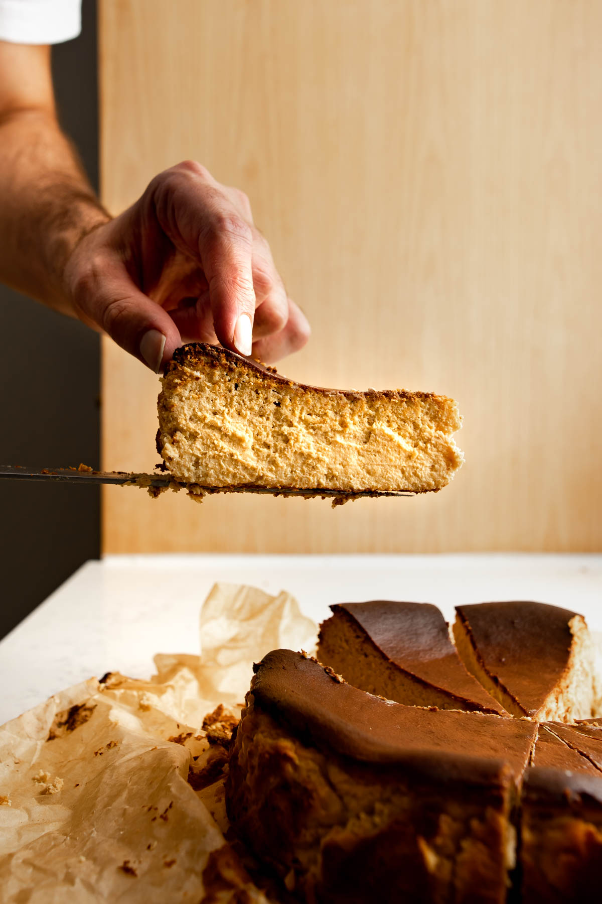 Slice of basque cheesecake pulled from the cake on a knife.